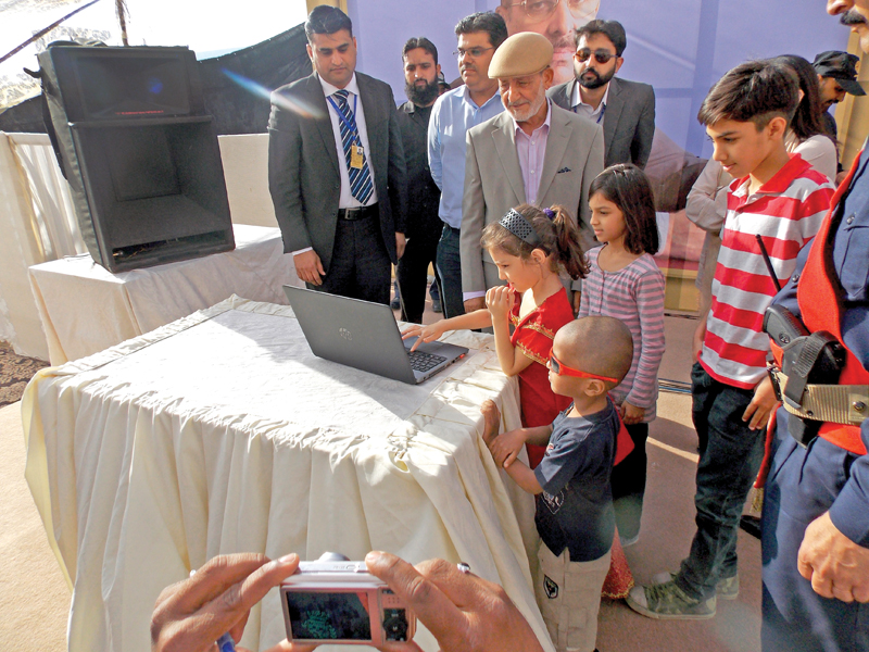bahria town executive director zain malik and vice chief executive mohammad ilyass look on as children press buttons for computer balloting for the bahria town plots in karachi on sunday photo express