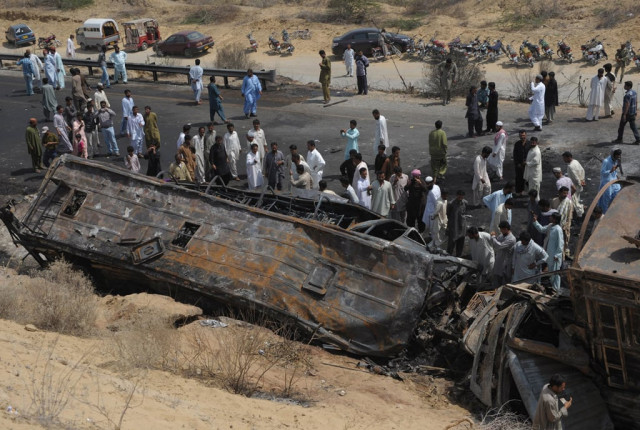 onlookers gather near the burnt wreckage of a passenger bus in hub near gadani on march 22 2014 photo afp onlookers gather near the burnt wreckage of a passenger bus in hub near gadani on march 22 2014 photo afp