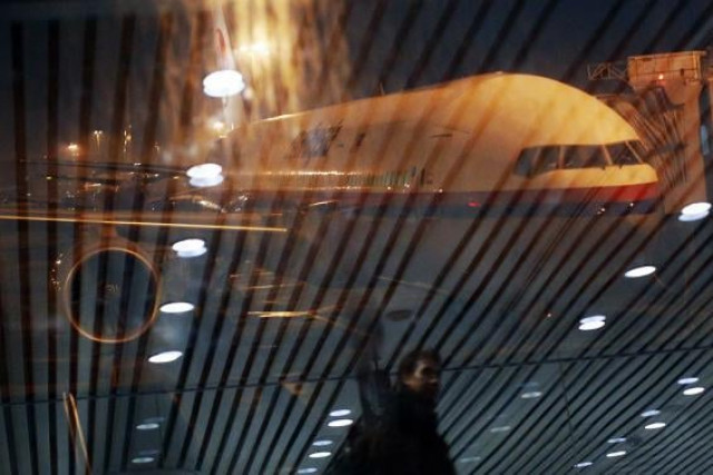 malaysia airlines boeing 777 200er flight mh318 to beijing sits on the tarmac as passengers are reflected on the glass at the boarding gate at kuala lumpur international airport photo reuters malaysia airlines boeing 777 200er flight mh318 to beijing sits on the tarmac as passengers are reflected on the glass at the boarding gate at kuala lumpur international airport photo reuters
