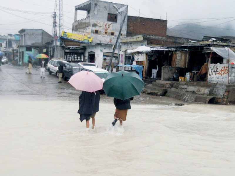 people wade through rainwater in buner photo nni