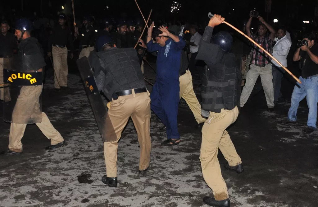 a file photo of police baton charging people photo afp a file photo of police baton charging people photo afp