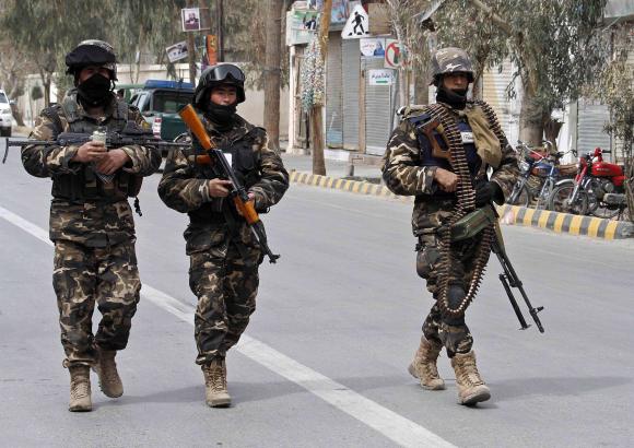 afghan national intelligence officers patrol after an assault by suicide attackers in kandahar march 12 2014 photo reuters