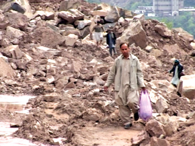 people walk through huge debris formed by the landslide near kohala in ajk photo express people walk through huge debris formed by the landslide near kohala in ajk photo express