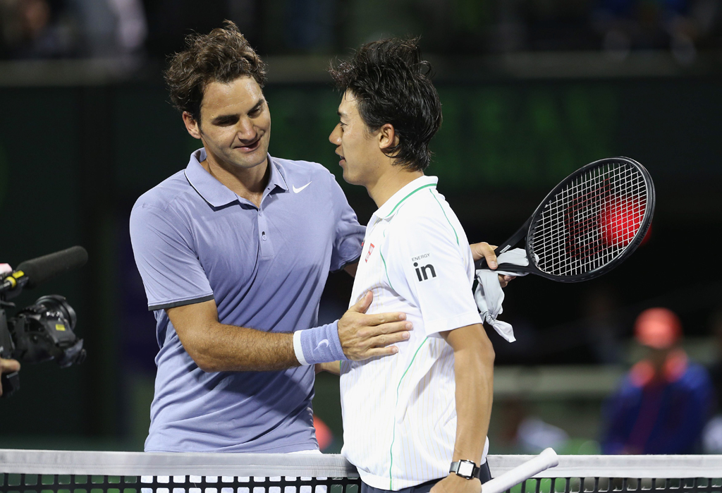 roger federer of switzerland at the net after his three set defeat congratulates kei nishikori of japan during their quarter final round match during day 10 at the sony open at crandon park tennis center on march 26 2014 in key biscayne florida photo afp