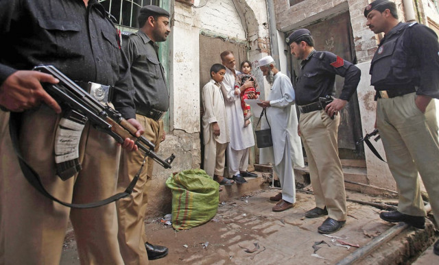 policemen stand guard as a polio worker waits to vaccinate a child at a street in the city as per a revised security plan for the polio campaign the number of police volunteers has been increased photo reuters policemen stand guard as a polio worker waits to vaccinate a child at a street in the city as per a revised security plan for the polio campaign the number of police volunteers has been increased photo reuters