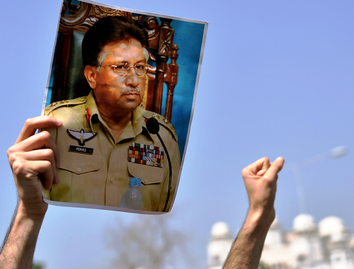 a supporter of former president pervez musharraf holds his photograph as he shout slogans during a protest outside a special court set up to try musharraf during a hearing in islamabad on march 31 2014 photo afp