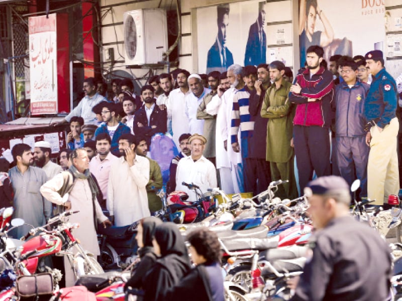 pedestrians wait as the police cordon off a street during the return of former military ruler pervez musharraf to afic photo afp