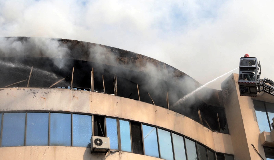 rescue official extinguishing the fire in lahore 039 s century plaza photo inp