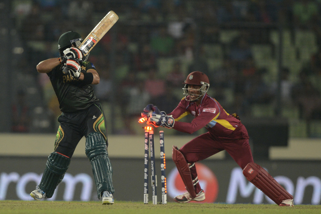 west indies wicketkeeper denesh ramdin r breaks the stumps of pakistan cricketer umar akmal l during the icc world twenty20 tournament group 2 cricket match between pakistan and west indies at the sher e bangla national cricket stadium in dhaka on april 1 2014 photo afp