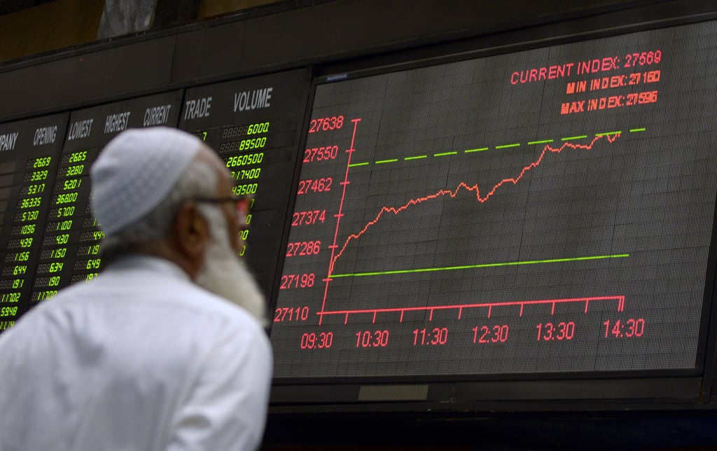 a pakistani stockbroker watches latest share prices on a digital board during a trading session at the karachi stock exchange kse in karachi on april 1 2014 photo afp