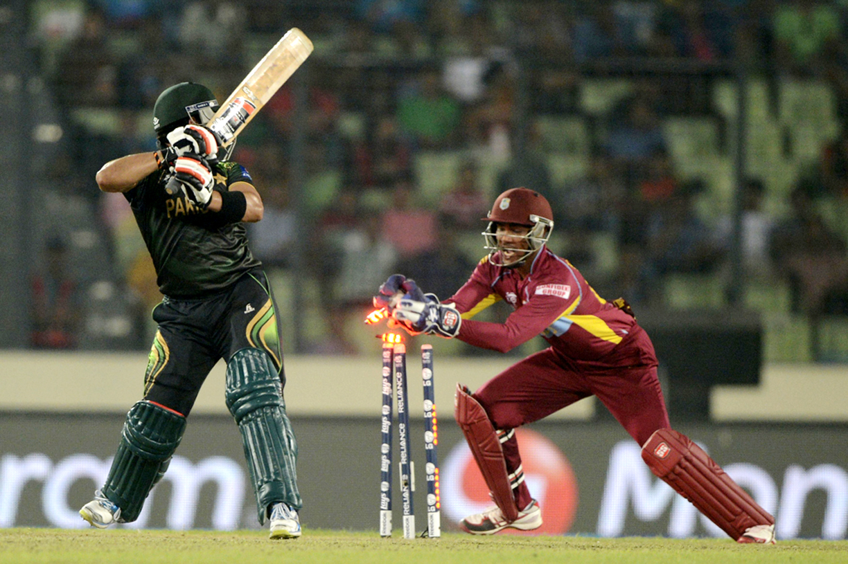 west indies wicketkeeper denesh ramdin r breaks the stumps of pakistan cricketer umar akmal l during the icc world twenty20 tournament group 2 cricket match between pakistan and west indies at the sher e bangla national cricket stadium in dhaka on april 1 2014 photo afp