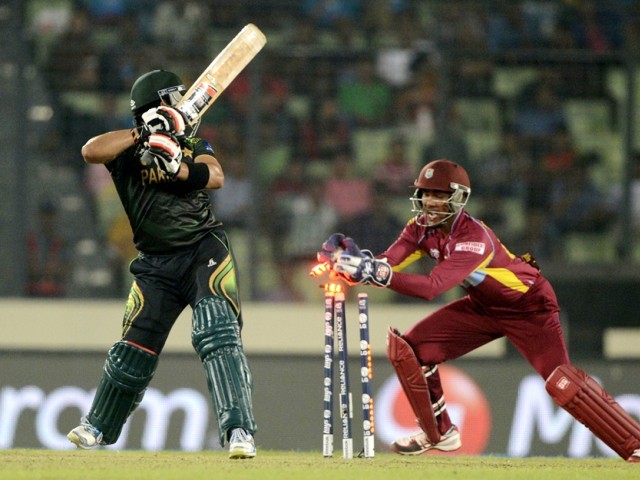 west indies wicketkeeper denesh ramdin r breaks the stumps of pakistan cricketer umar akmal l during the icc world twenty20 tournament group 2 cricket match between pakistan and west indies at the sher e bangla national cricket stadium in dhaka on april 1 2014 photo afp