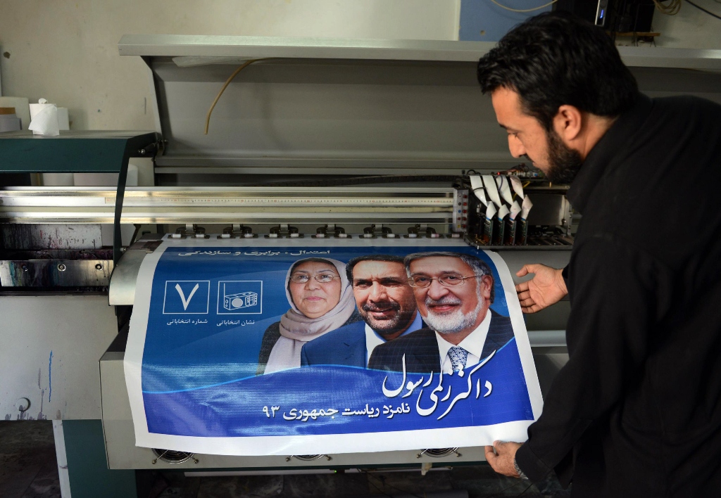 pakistani employee printing electoral posters of an afghan presidential candidate zalmai rassoul at a printing press in peshawar photo afp