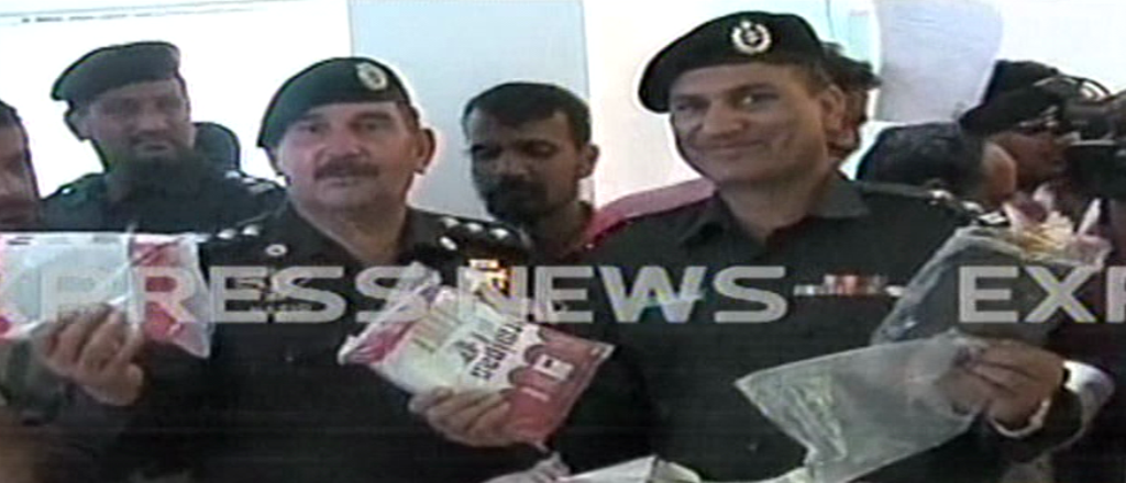 express news screengrab of a police officer holding packets of hashish that were seized