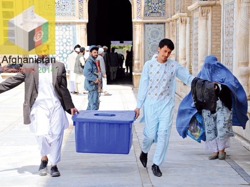 afghan election workers carry a plastic box containing election material into a polling station at jamee mosque in the city of herat photo afp