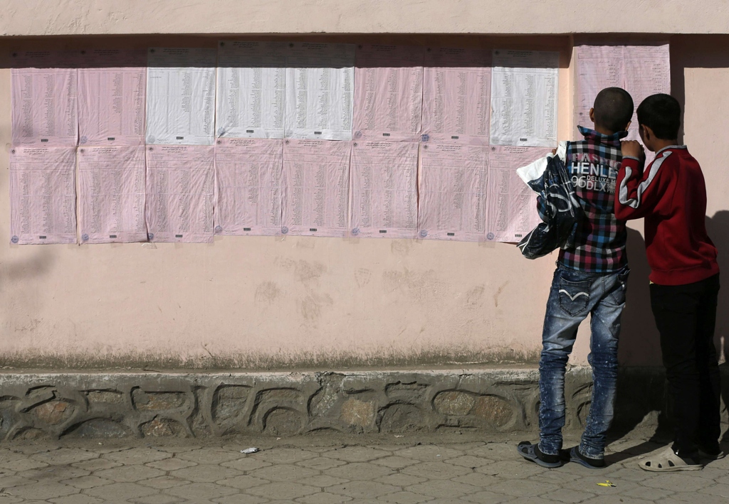 afghan boys look on a preliminary list taped to the wall of a polling station in kabul photo reuters