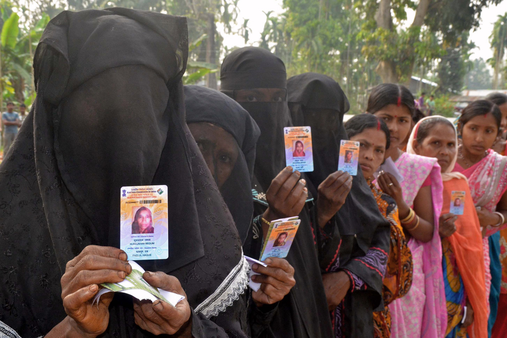 indian muslim voters pose with identification as they wait in line to vote outside a polling station in koliabor in assam state 039 s nagoan district some 180 kms east of guwahati on april 7 2014 photo afp