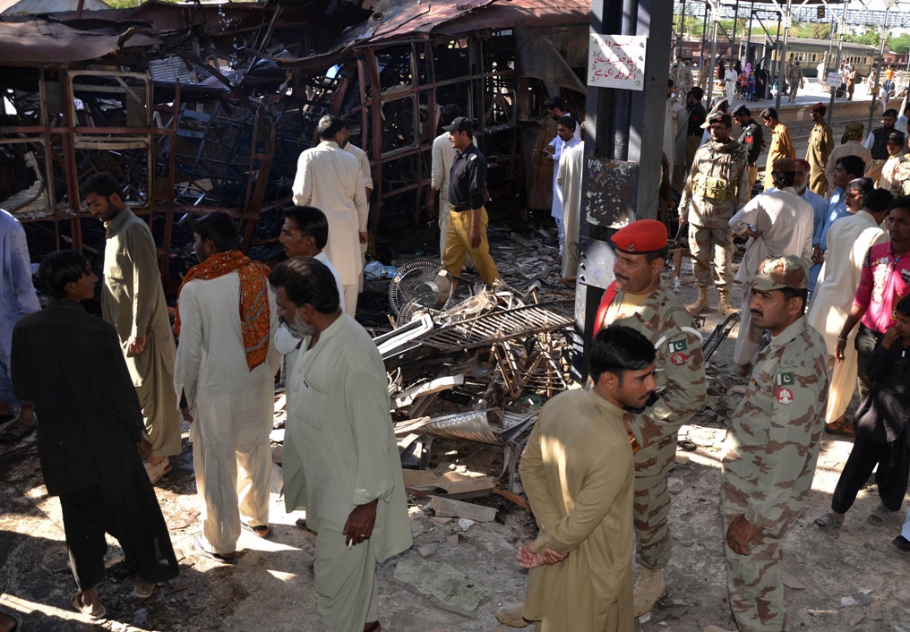 pakistani security officials and local residents gather beside the wreckage of a train after a bomb attack at the sibi railway station some 160 kilometres south of the train 039 s destination quetta on april 8 2014 photo afp