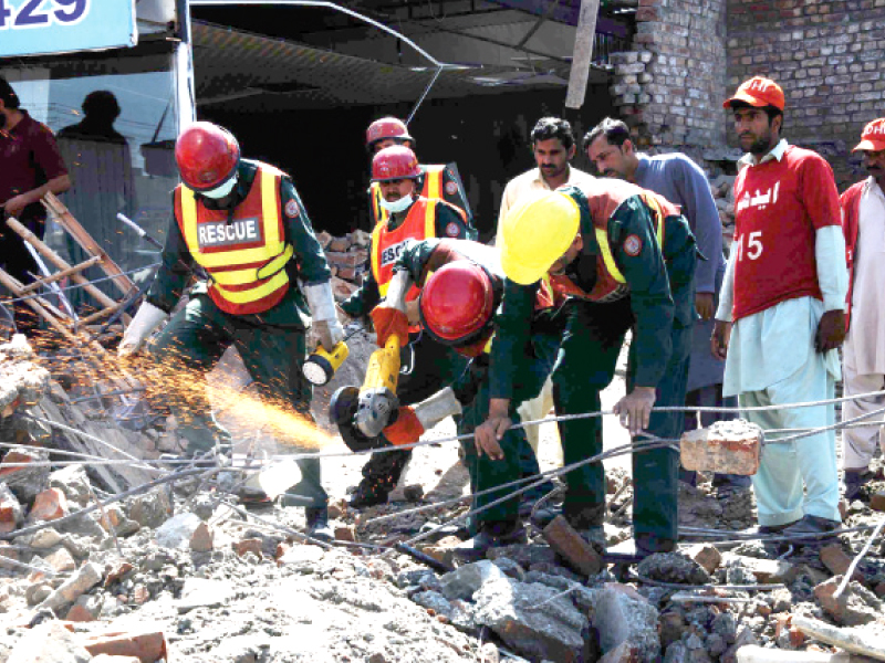 rescue 1122 officials use cranes to lift debris and circular saws to cut through construction steel to reach those trapped under the roof debris photo shafiq malik and abid nawaz express