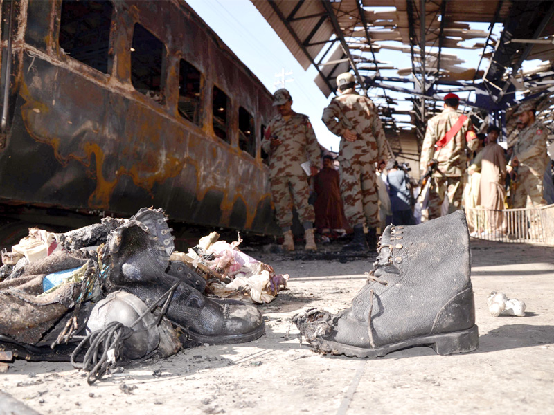 security officials gather beside the wreckage of the train after an attack at the sibi railway station photo afp