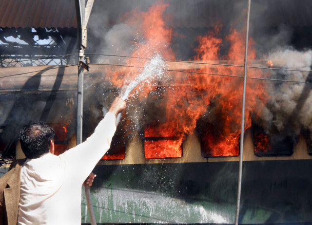 a pakistani railway official extinguishes fire after a bomb blast on a train at the sibi railway station some 160 kilometres south of its destination quetta on april 8 2014 photo afp a pakistani railway official extinguishes fire after a bomb blast on a train at the sibi railway station some 160 kilometres south of its destination quetta on april 8 2014 photo afp