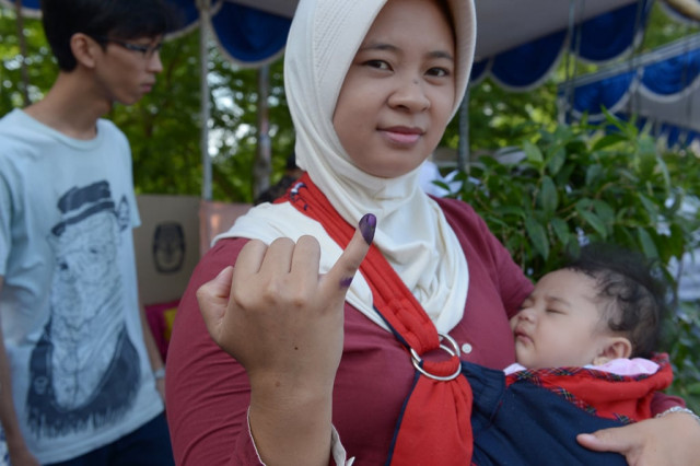 a young family leaves a polling station during legislative elections in jakarta on april 9 2014 photo afp a young family leaves a polling station during legislative elections in jakarta on april 9 2014 photo afp