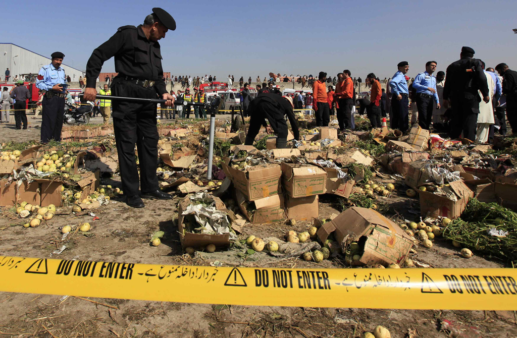 a police official uses a metal detector to search the site of a bomb blast at a vegetable and fruit market in the outskirts of islamabad april 9 2014 photo reuters