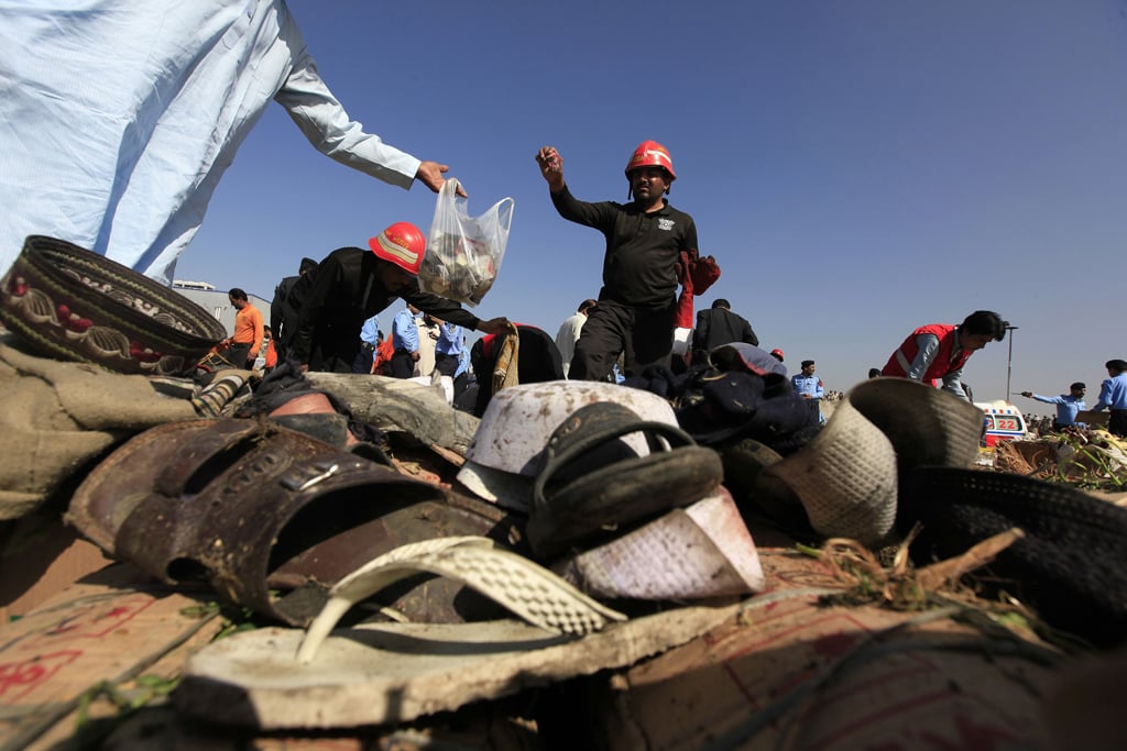 rescue workers are seen collecting evidence behind footwear after a bomb blast at a vegetable and fruit market in the outskirts of islamabad april 9 2014 photo reuters