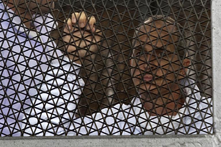 peter greste australian journalist for al jazeera stands in the defendants cage during his trial photo afp