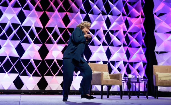 former secretary of state hillary clinton ducks after a woman threw an object toward her while she was delivering remarks at the institute of scrap recycling industries conference on april 10 2014 in las vegas nevada photo afp