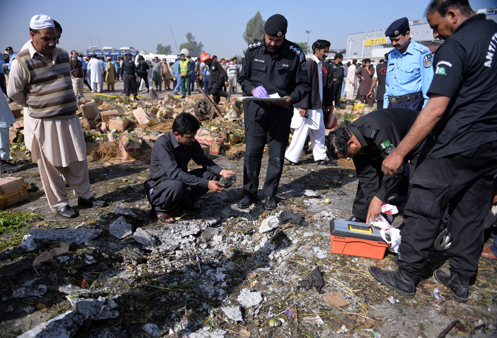 security officials inspect the site of a bomb explosion in a fruit and vegetable market in islamabad on april 9 2014 photo afp