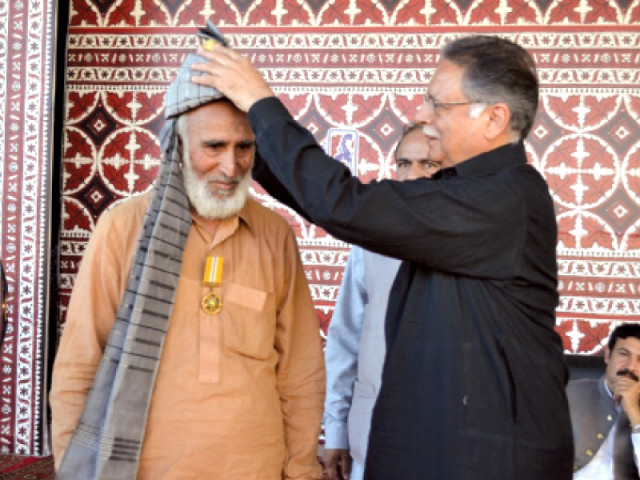 minister for information pervaiz rashid honouring ameer bukhsh during the ceremony a troupe from balochistan presenting a folk dance photo express