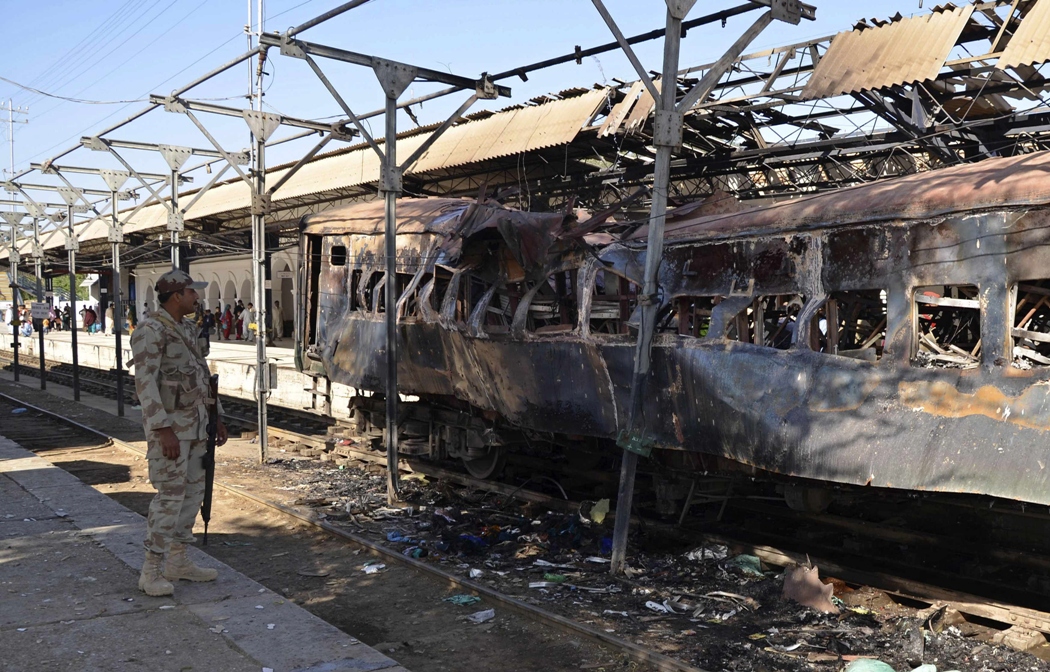 a paramilitary soldier stands near a damaged passenger carriage at the site of a bomb blast in the town of sibi april 8 2014 photo reuters