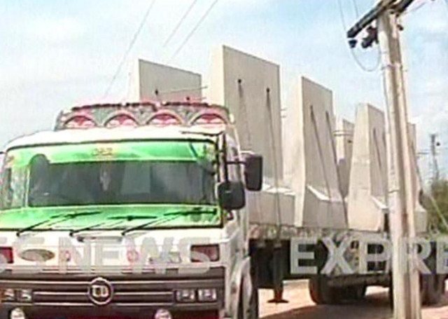 express news screengrab of a truck transporting materials for the wall to farmhouse