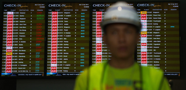 a worker walks in front of check in time screens at the new low cost airport at kuala lumpur international airport 2 klia2 during the operational readiness and transfer orat exercise in sepang outside kuala lumpur on april 12 2014 photo afp