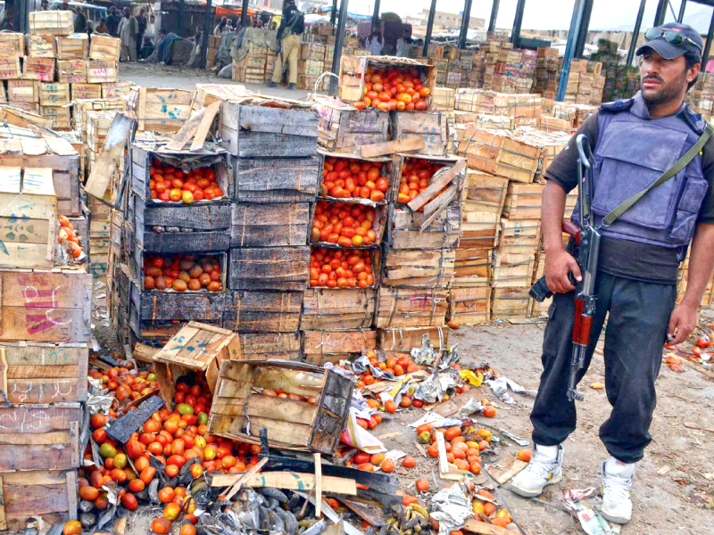 a paramilitary man stands next to the tomato crates damaged in the blasts photo ppi