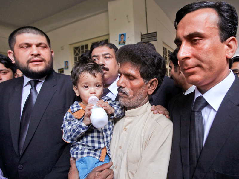 nine month old musa khan carried by his grandfather as they leave the court in lahore photo reuters