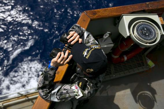 able seaman boatswains mate marc chandler looks through a pair of binoculars in search of the missing malaysian airlines flight mh370 photo reuters