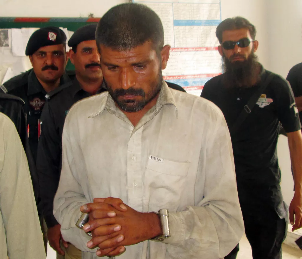 arif arrested on suspicion of cannibalism is escorted to a police station in bhakkar district on april 14 2014 photo afp arif arrested on suspicion of cannibalism is escorted to a police station in bhakkar district on april 14 2014 photo afp
