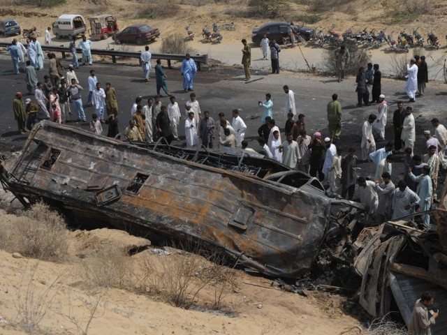 onlookers gather near the burnt wreckage of a passenger bus in hub near gadani on march 22 2014 photo afp onlookers gather near the burnt wreckage of a passenger bus in hub near gadani on march 22 2014 photo afp