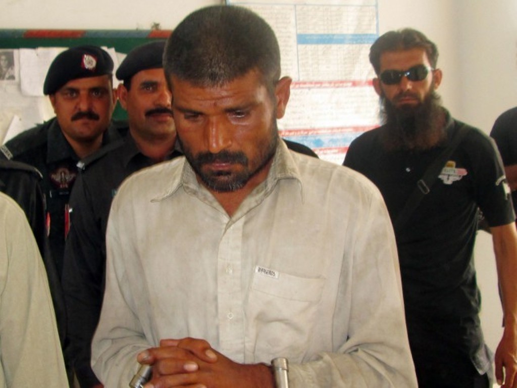 arif arrested on suspicion of cannibalism is escorted to a police station in bhakkar district on april 14 2014 photo afp