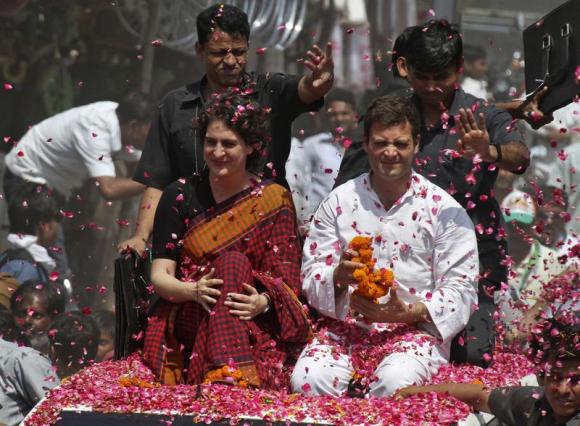 rahul gandhi in white and his sister priyanka gandhi vadra are showered with rose petals by their supporters upon rahul 039 s arrival to file his nomination for the general election at amethi in uttar pradesh april 12 2014 photo reuters