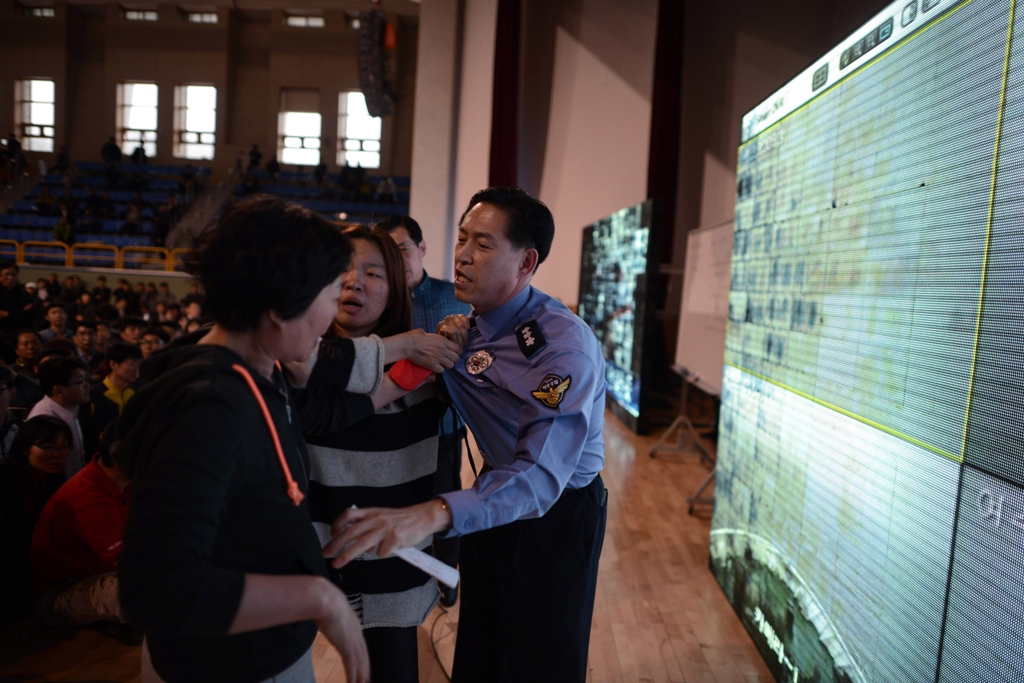 a woman confronts police chief choi sang han c as relatives of missing passengers aboard a capsized ferry express frustration at conflicting reports of progress in the ongoing rescue and recovery operation photo afp