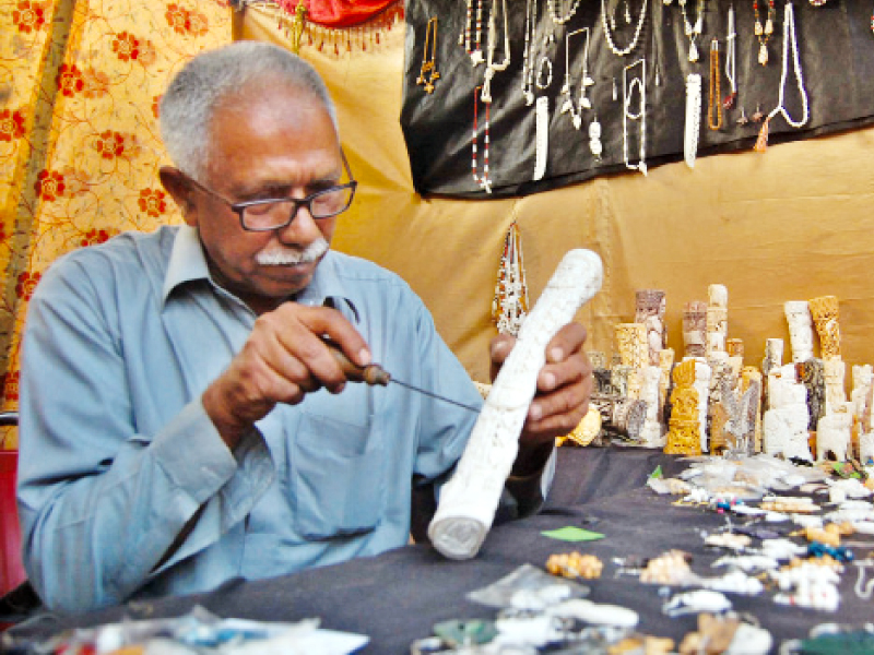 qureshi applying finishing touches to a decoration piece at his stall at lok mela photo muhammad javaid express