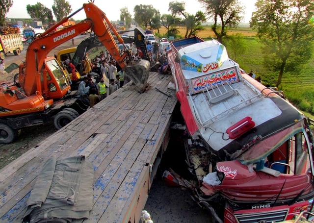 rescuers use excavators to pull a tractor trailer from a passenger bus after an accident in sukkur photo afp