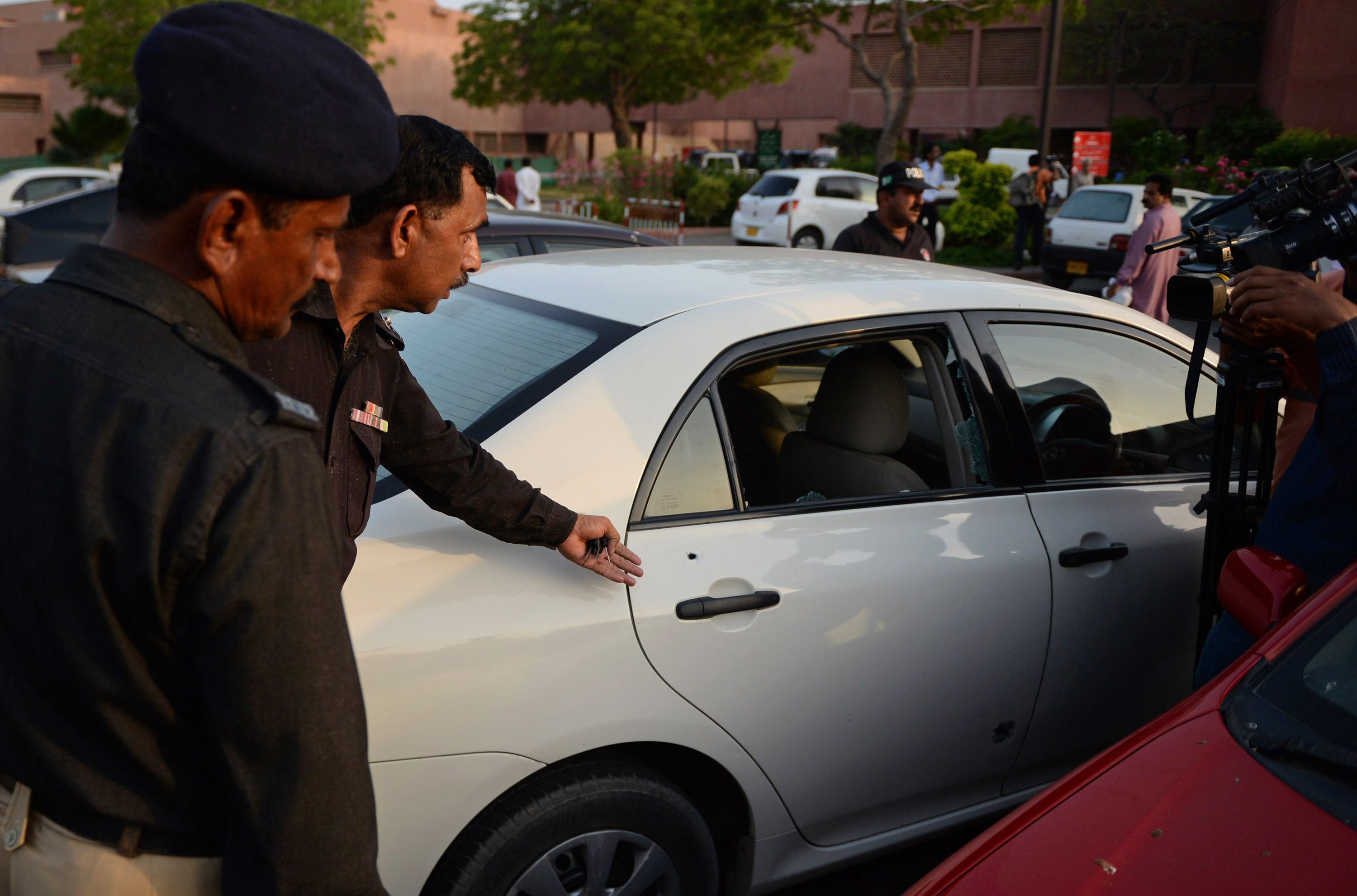 a policeman shows the media a bullet hole in the door of a car which belongs to journalist hamid mir at a local hospital in karachi april 19 2014 photo afp