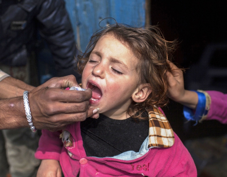 a polio worker gives polio vaccine drops to a child photo reuters
