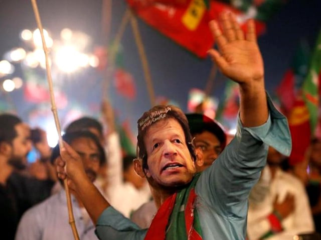 a supporter of imran khan wears a mask and dances on party songs during a campaign rally ahead of general elections in karachi july 22 2018 photo reuters