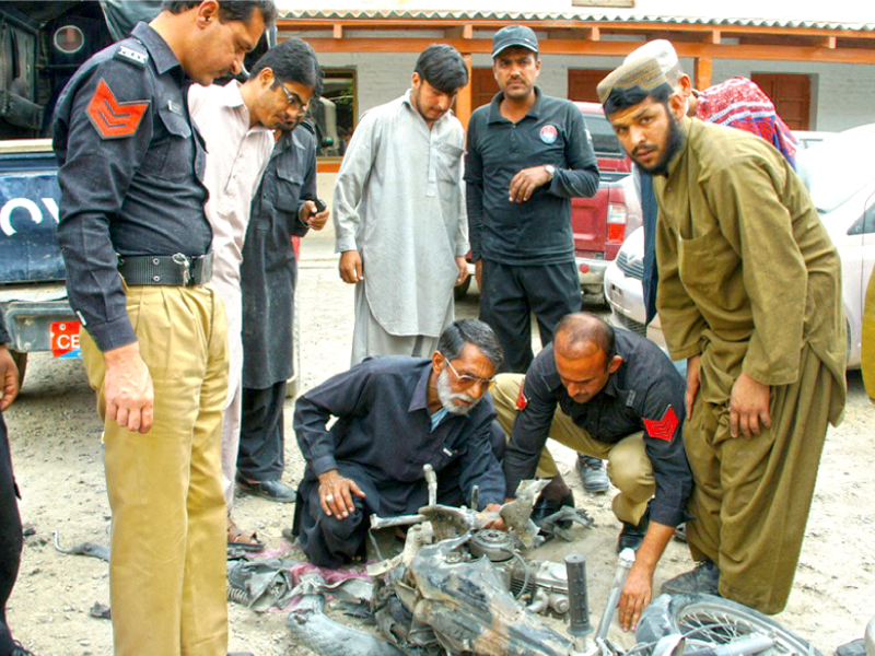 police officials check the wreckage of the motorcycle used in the bomb explosion in chaman on monday photo express