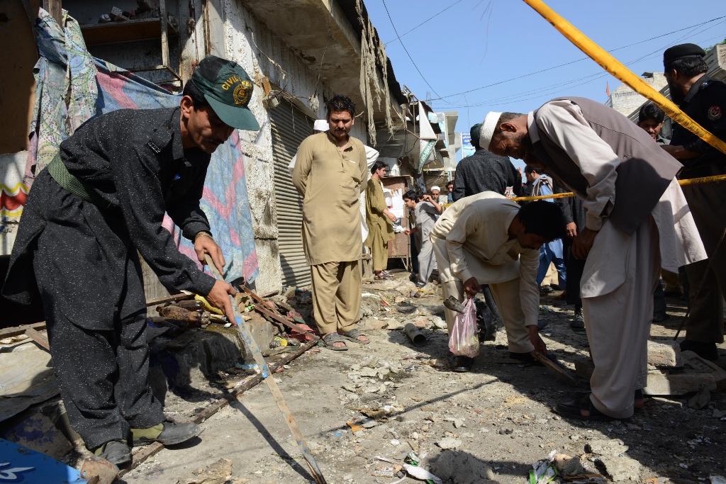 police officials collect evidence at the site of a bomb attack in charsadda photo afp